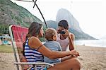 Man taking photograph of mother and son on chair, Rio de Janeiro, Brazil