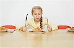 Girl sitting at table with plate full of spaghetti