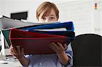 Boy holding pile of ring binders