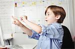 Boy playing with elastic band in office