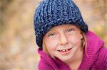 A Girl In A Knitted Hat, And Magenta Jumper With A Folded Collar.