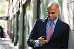 Business People. A Businessman In A Suit And Red Tie, Checking His Phone.