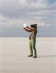 A Man Wearing A Horse Mask, Taking A Photograph With A Tablet Device, On Bonneville Salt Flats.