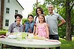 A Summer Family Gathering At A Farm. Five People Posing Beside The Table, Where A Child Is Making Fresh Lemonade.