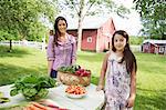 Family Party. Two People, Girls, Standing Beside A Table Set For A Summer Meal.