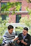 Summer. Business People. Two Men Sitting Using A Digital Tablet.