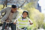 A Family In The Park On A Sunny Day. Father And Son Bicycling