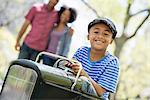 A Boy Riding An Old Fashioned Toy Peddle Car.