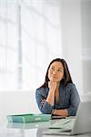 Business. A Woman Sitting Relaxing, With Her Chin On Her Hand.