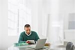 Business. A Light Airy Office Environment. A Man Sitting Holding A Digital Tablet.