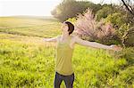 Young Woman Standing In Grassy Field In Spring.