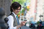 A Young Business Man On The Street Checking His Smart Phone.