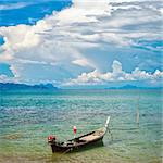 traditional thai long boat on beach in Thailand