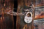 Old rusty padlock and chain on the rural wooden gate