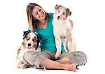 purebred australian shepherds and woman  in front of white background