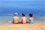 Three children relaxing together at the beach