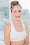 Cheerful athletic blonde posing in bright room