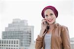 Cheerful casual blonde on the phone outdoors on urban background