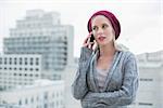 Serious pretty blonde on the phone outdoors on urban background