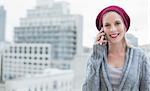 Cheerful pretty blonde on the phone outdoors on urban background