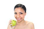 Beautiful young dark haired model holding a green apple on white background