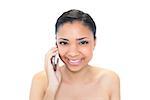 Happy young dark haired model making a phone call on white background