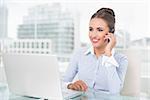 Smiling businesswoman phoning in bright office