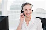 Happy call centre agent looking at camera in her office