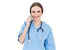 Young woman doctor phoning with her smartphone while smiling into the camera