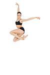 Cheerful slim ballet dancer jumping in the air on white background