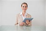 Smiling stylish businesswoman using tablet in bright office