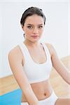 Portrait of a toned brunette sitting at fitness studio