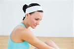 Close up side view of a thoughtful toned woman in fitness studio