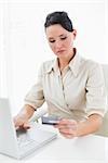 Young businesswoman doing online shopping through laptop and credit card