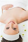 Overhead portrait of a young beautiful woman lying on massage table in beauty salon