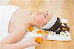 Side view of a beautiful young woman with eyes closed and flowers in beauty salon