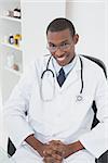 Portrait of a confident smiling male doctor sitting at medical office