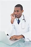 Concentrated male doctor using laptop at medical office