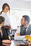 Business people ordering a dinner from waitress in the restaurant