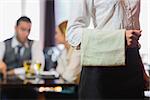 Waitress standing in front of two business people talking in a restaurant