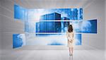 Rear view of businesswoman looking at futuristic server towers in blue light