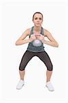 Young woman training her body with a kettle bell on white screen