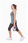 Sporty woman training her body walking with a kettle bell on white screen