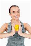 Content woman holding a massage ball between her hands on white background