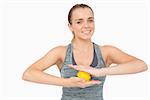 Happy woman holding yellow massage ball between her hands smiling at camera