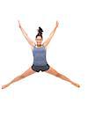 Smiling sporty brunette jumping in the air on white background