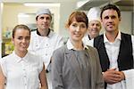 Young female manager posing in a modern kitchen with the staff