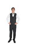 Attractive waiter posing with hands on hips smiling at camera