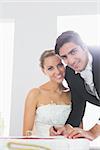 Handsome young bridegroom signing wedding contract smiling at camera