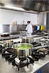 Several pots cooking on hotplate in professional kitchen